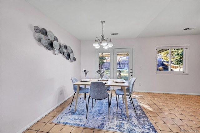 dining room with light tile patterned floors and a chandelier