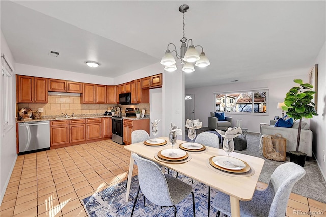 dining space with light tile patterned floors, sink, and a chandelier