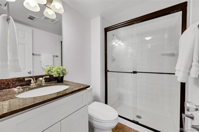 bathroom with tile patterned floors, vanity, toilet, and walk in shower