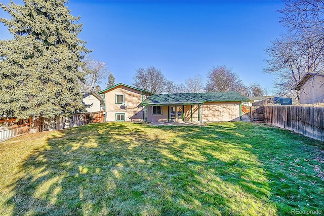 rear view of property featuring a lawn