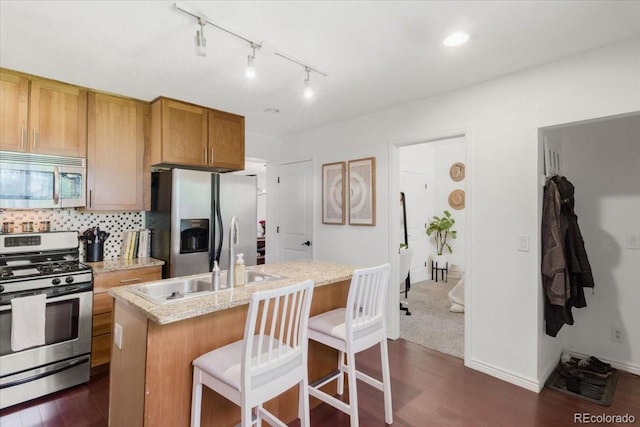3929 Shoshone St, Denver, CO 80211 - kitchen featuring stainless steel appliances, a sink, dark wood finished floors, an island with sink, and backsplash
