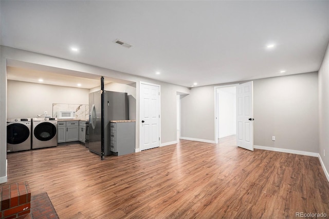 interior space with washing machine and clothes dryer, recessed lighting, visible vents, and wood finished floors