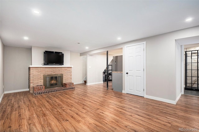 unfurnished living room with stairway, baseboards, recessed lighting, and wood finished floors