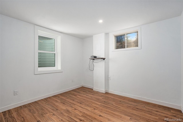 empty room featuring baseboards, recessed lighting, and wood finished floors