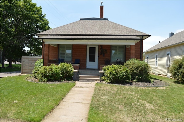 1215 10th Ave, Greeley, CO 80631 - bungalow with brick siding, a porch, and a front lawn