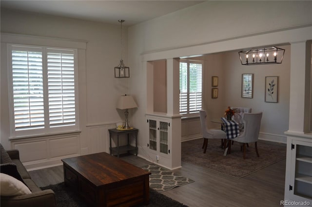 1215 10th Ave, Greeley, CO 80631 - living room featuring wood finished floors, a chandelier, wainscoting, and a decorative wall