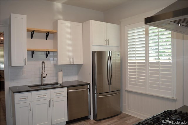 1215 10th Ave, Greeley, CO 80631 - kitchen featuring appliances with stainless steel finishes, range hood, open shelves, tasteful backsplash, and dark countertops