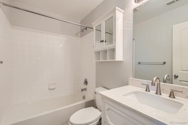 full bathroom featuring vanity, tiled shower / bath combo, and toilet