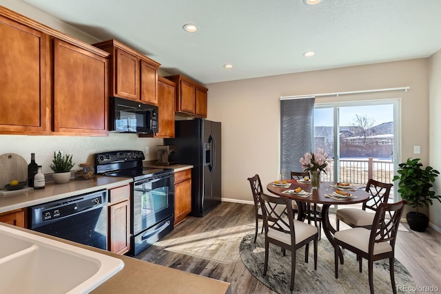 kitchen with black appliances and dark hardwood / wood-style floors