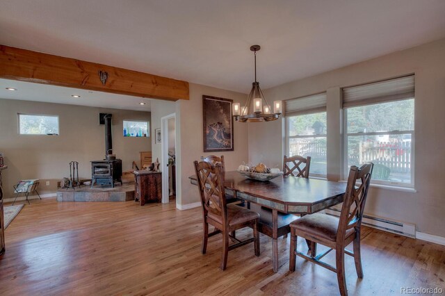 136 W Buckskin Rd, Alma, CO 80420 - dining space with a healthy amount of sunlight, light wood-style floors, a wood stove, and a chandelier
