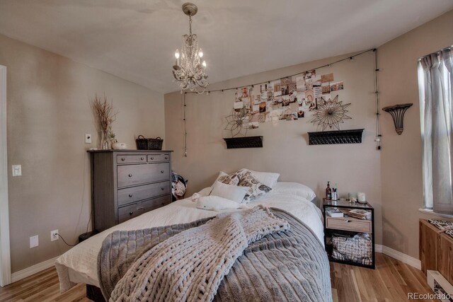 136 W Buckskin Rd, Alma, CO 80420 - bedroom featuring baseboards, visible vents, wood finished floors, and a chandelier