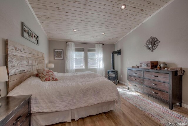 136 W Buckskin Rd, Alma, CO 80420 - bedroom featuring baseboards, light wood-type flooring, wooden ceiling, and a wood stove