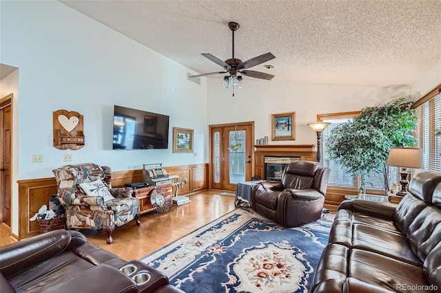 living room with wood-type flooring, a textured ceiling, ceiling fan, and lofted ceiling