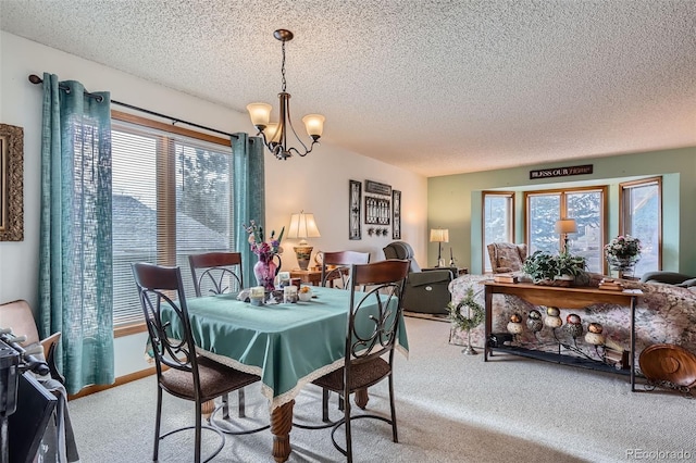 carpeted dining room featuring a wealth of natural light, a textured ceiling, and a notable chandelier