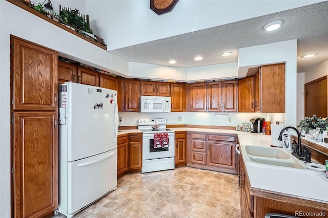 kitchen with sink, white appliances, and a textured ceiling