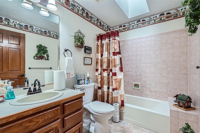 full bathroom with a skylight, vanity, shower / bath combo, and toilet