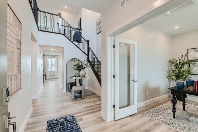 foyer with recessed lighting, stairway, light wood-type flooring, and baseboards