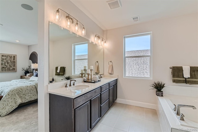 ensuite bathroom with connected bathroom, visible vents, and a sink