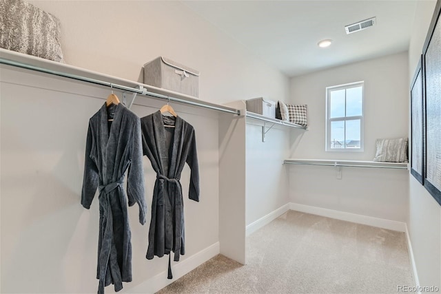 spacious closet featuring visible vents and light colored carpet