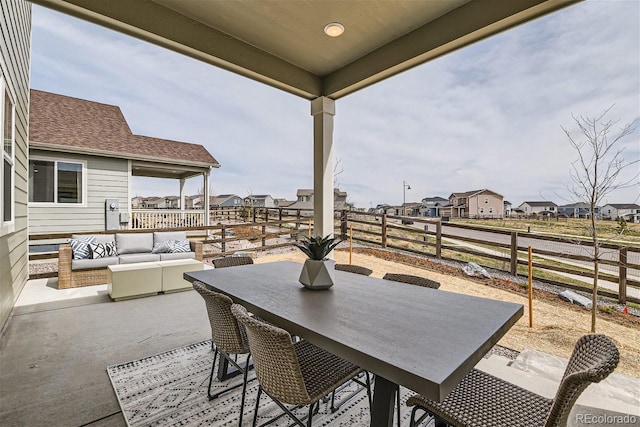 view of patio featuring an outdoor living space, outdoor dining space, fence, and a residential view