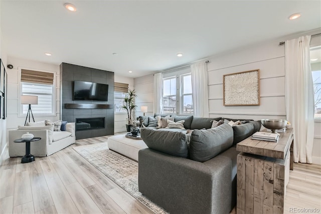 living area with light wood-type flooring, a fireplace, and recessed lighting