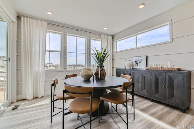 dining room with light wood finished floors, visible vents, and recessed lighting