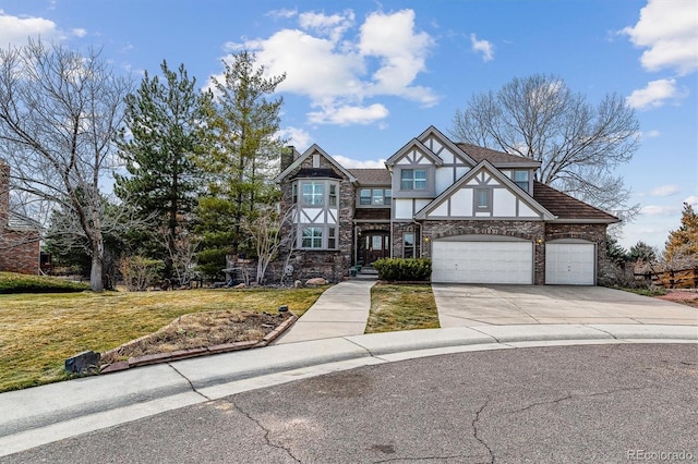 tudor house featuring an attached garage, a front lawn, concrete driveway, and stucco siding