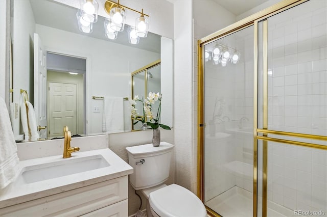 bathroom featuring toilet, a stall shower, and vanity