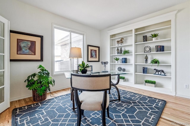 office area with baseboards and wood finished floors