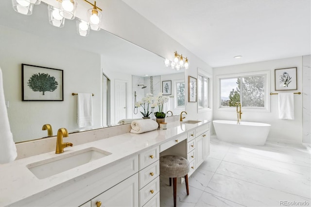 bathroom featuring marble finish floor, double vanity, a freestanding tub, and a sink