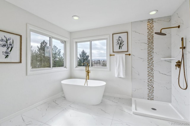 full bath with a marble finish shower, marble finish floor, a freestanding tub, and baseboards