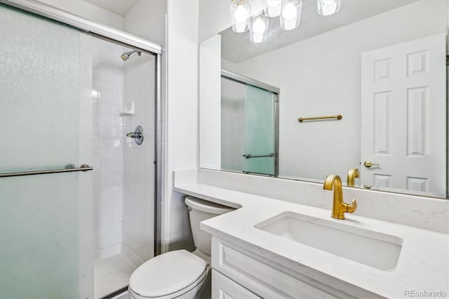 bathroom featuring a stall shower, vanity, and toilet