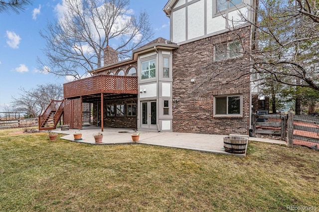 rear view of house with brick siding, a yard, a patio, stairway, and a wooden deck