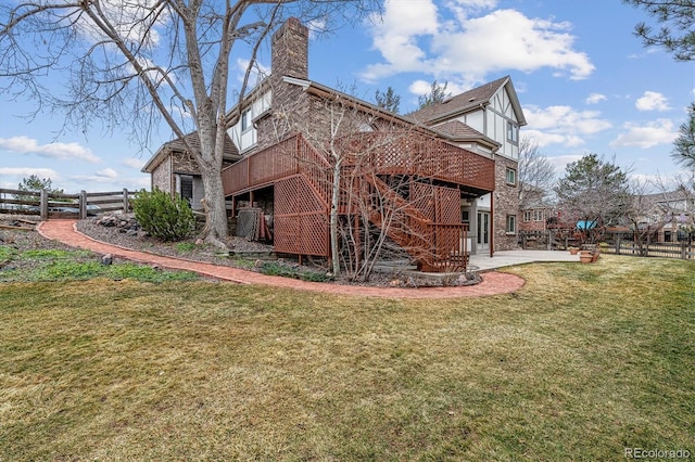 back of house featuring a patio, a lawn, a chimney, and fence