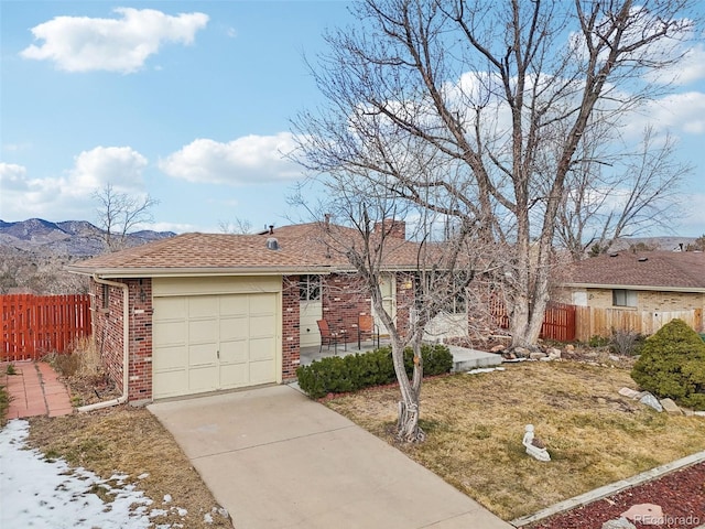 single story home featuring a garage, a front yard, and a mountain view