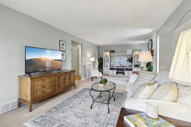 carpeted living room featuring a textured ceiling