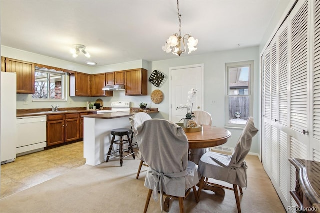 dining space with a notable chandelier, sink, and light tile patterned flooring