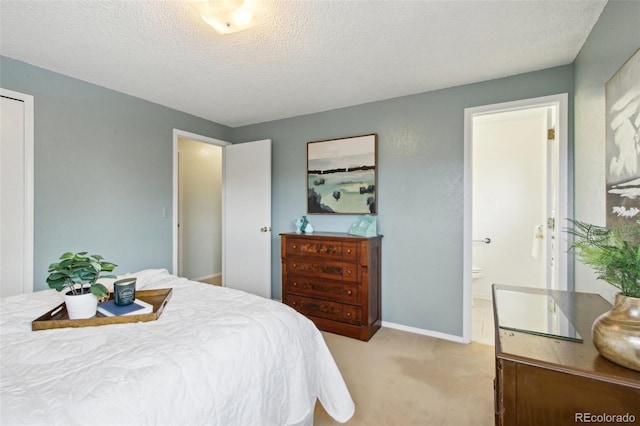 carpeted bedroom with a textured ceiling and ensuite bath