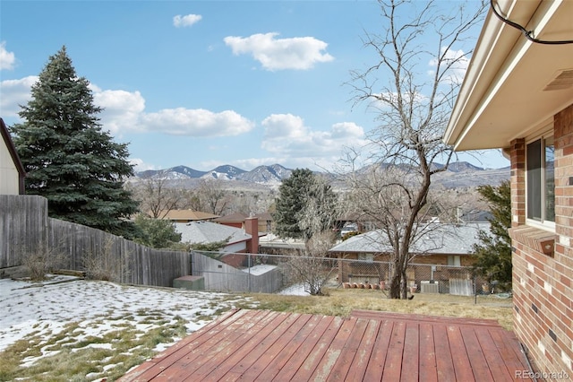 snow covered deck with a mountain view