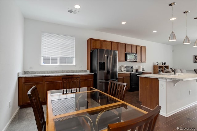 9643 Birch Ln, Thornton, CO 80229 - kitchen featuring black appliances, a sink, light countertops, hanging light fixtures, and brown cabinets