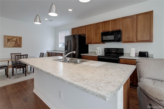 9643 Birch Ln, Thornton, CO 80229 - kitchen with black appliances, dark wood-style flooring, a sink, brown cabinets, and light countertops