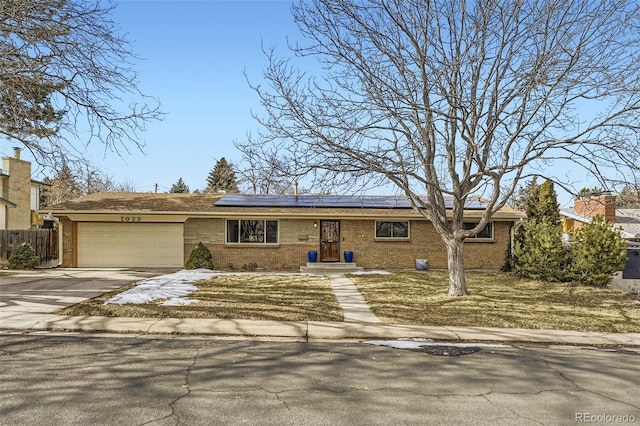 view of front of property with a garage and solar panels