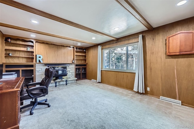 carpeted office space featuring wooden walls and beam ceiling