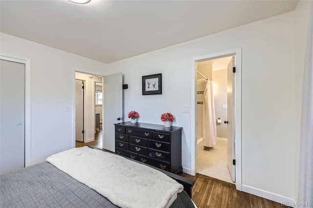 bedroom with dark hardwood / wood-style floors and ensuite bathroom