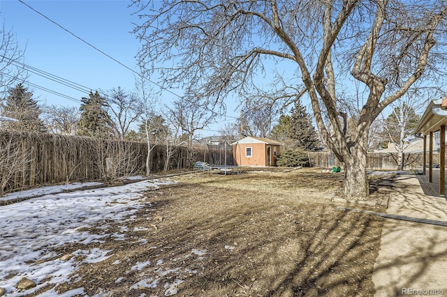 yard covered in snow with a storage shed