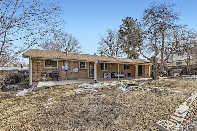 rear view of property featuring a fire pit and a patio area