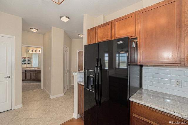 13456 Via Varra Unit 140, Broomfield, CO 80020 - kitchen with black refrigerator with ice dispenser, brown cabinets, decorative backsplash, and light stone counters