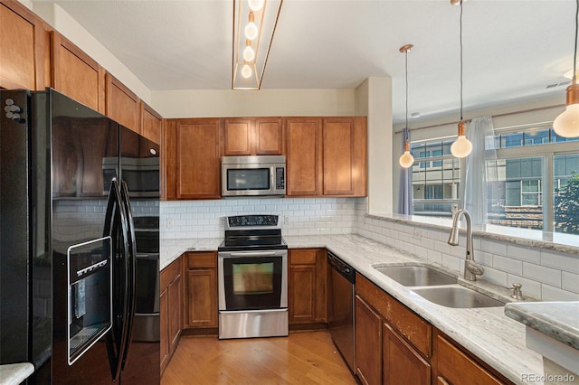 13456 Via Varra Unit 140, Broomfield, CO 80020 - kitchen featuring stainless steel appliances, brown cabinetry, light wood-style floors, and backsplash