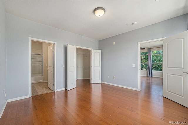 13456 Via Varra Unit 140, Broomfield, CO 80020 - unfurnished bedroom featuring light wood-type flooring, a spacious closet, and connected bathroom