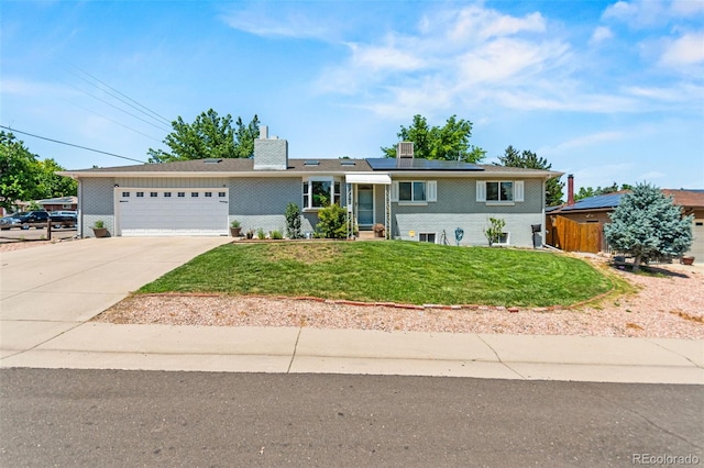 3397 W Tanforan Dr, Englewood, CO 80110 - view of front facade featuring driveway, an attached garage, roof mounted solar panels, and a chimney